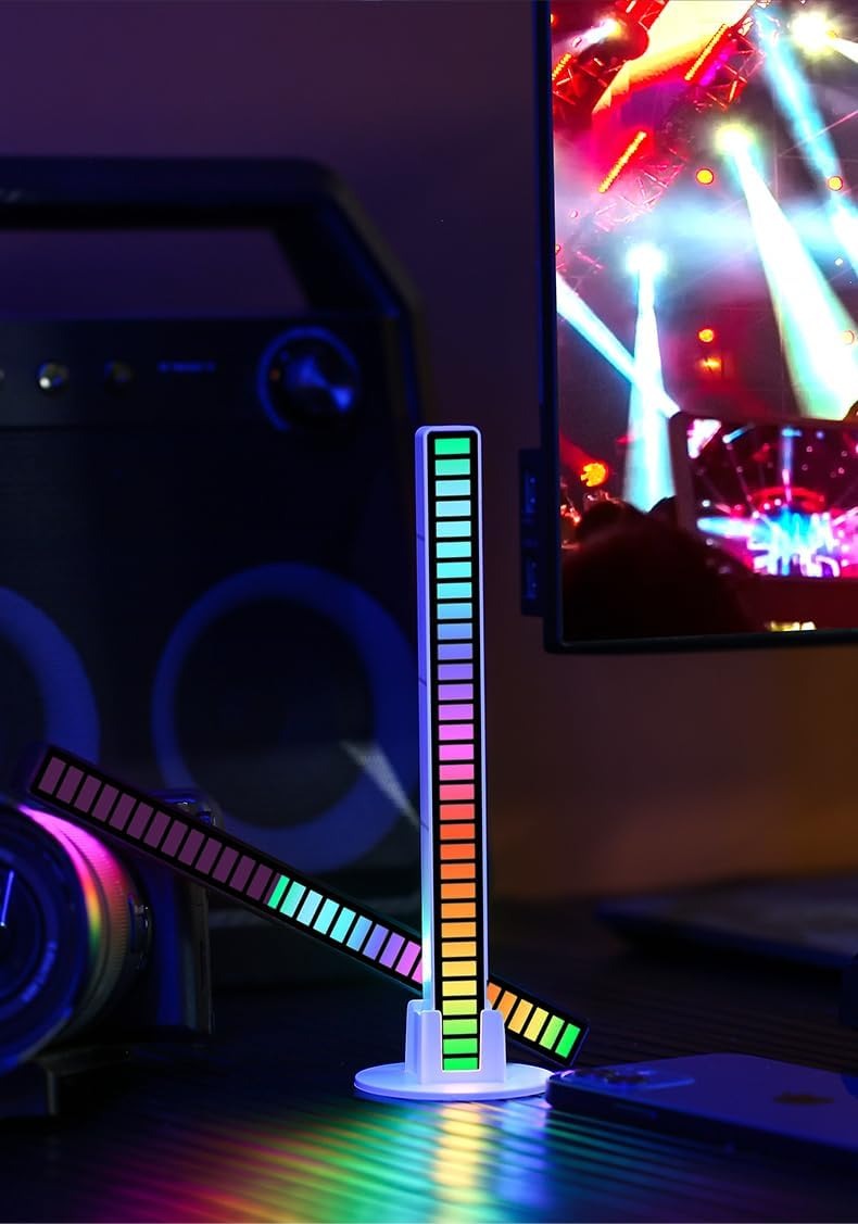 Colorful LED desk lamp on a desk with a computer setup in the background